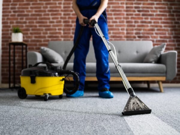Janitor Cleaning Carpet With Vacuum Cleaner